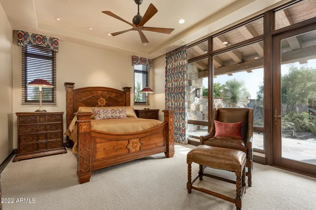 a bedroom with a bed and large windows