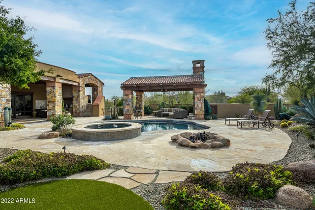 a front view of a house with swimming pool garden and patio