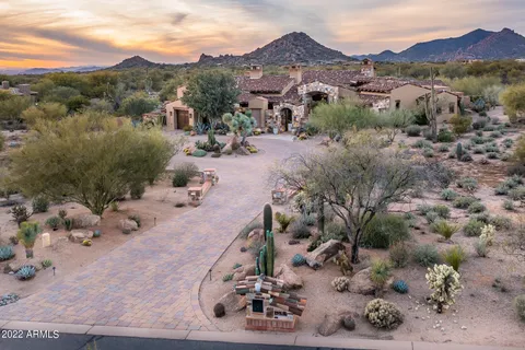 an aerial view of a house with a mountain