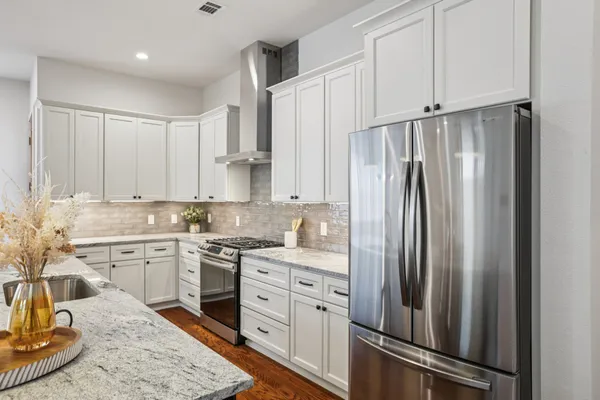 a kitchen with kitchen island granite countertop a sink stainless steel appliances and cabinets