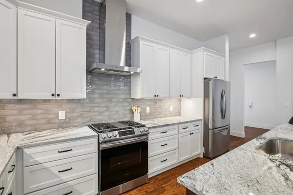 a kitchen with stainless steel appliances a refrigerator sink and cabinets