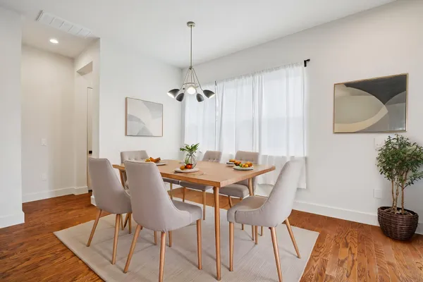 a kitchen with stainless steel appliances granite countertop a sink a stove a refrigerator and a island with wooden floor