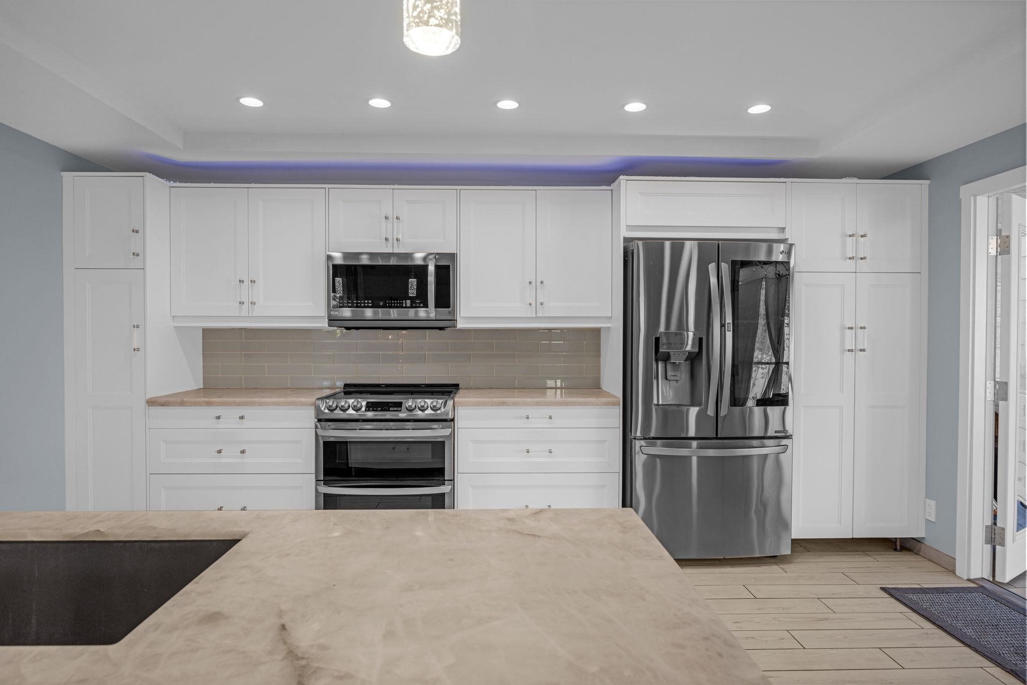 100 Auhana Road, Unit 103 Kihei, HI 96753 - Photo 11 of 43 a kitchen with granite countertop stainless steel appliances and refrigerator