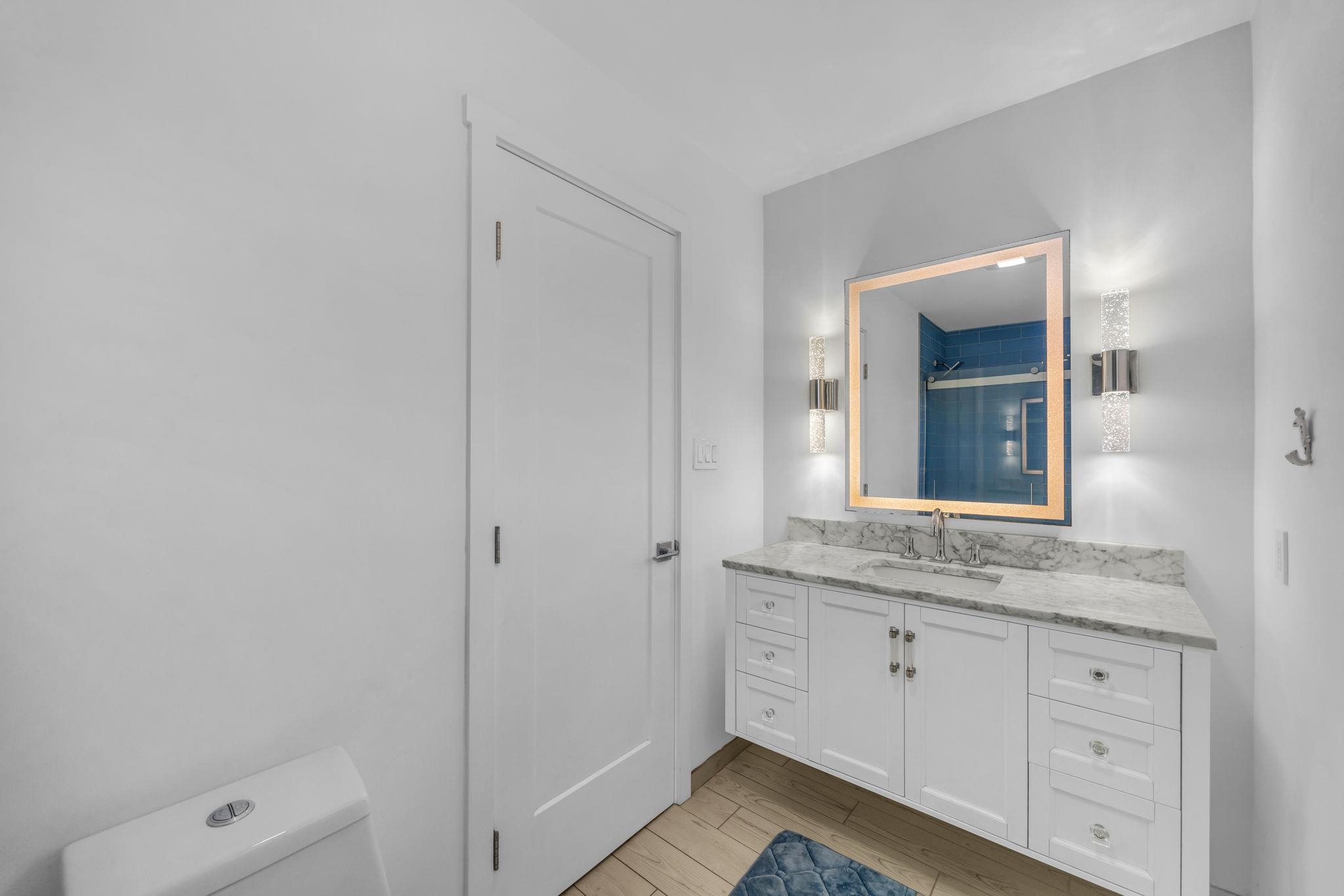 100 Auhana Road, Unit 103 Kihei, HI 96753 - Photo 21 of 43 a bathroom with a granite countertop sink and mirror with toilet