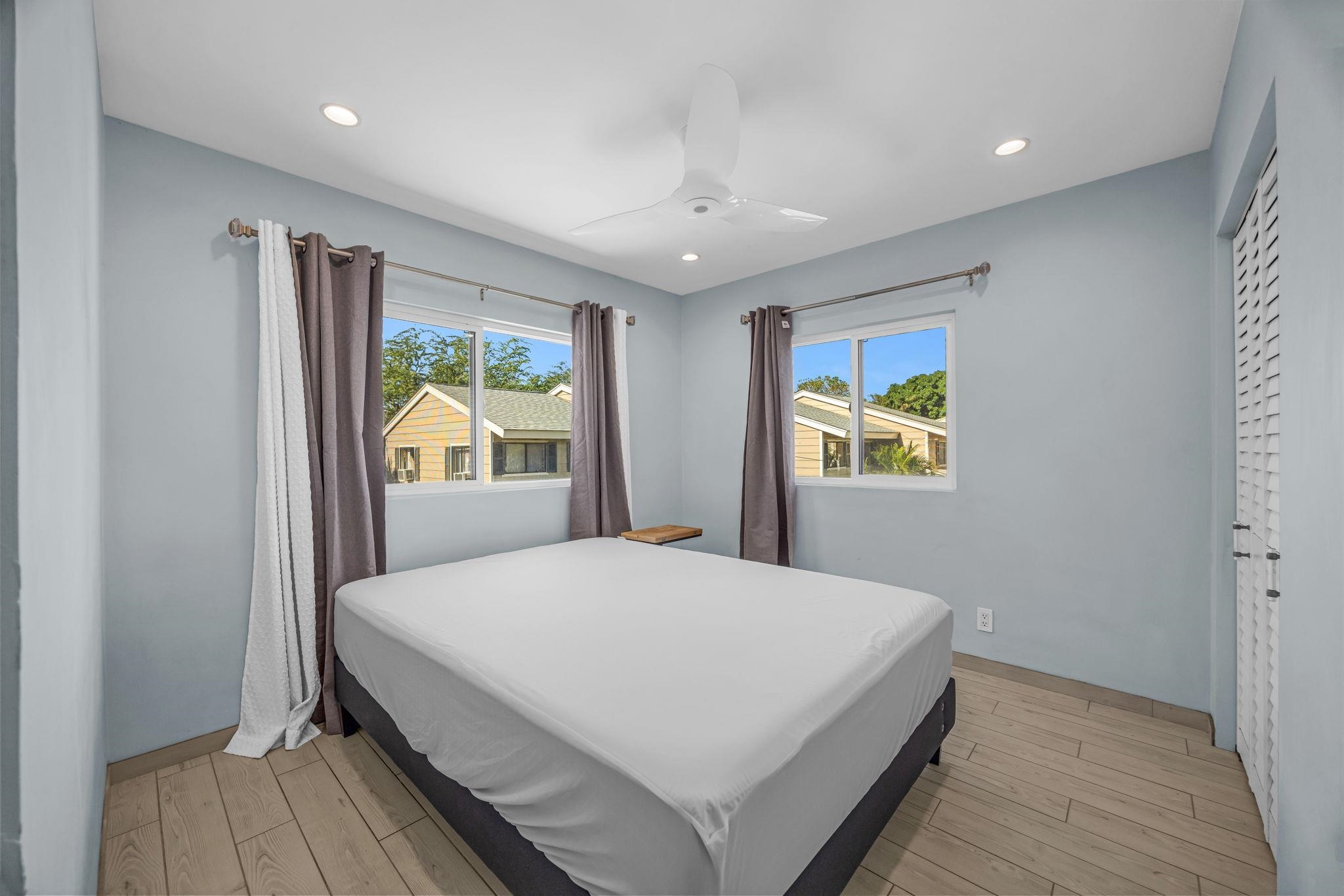 100 Auhana Road, Unit 103 Kihei, HI 96753 - Photo 24 of 43 a bedroom with a bed and wooden floor