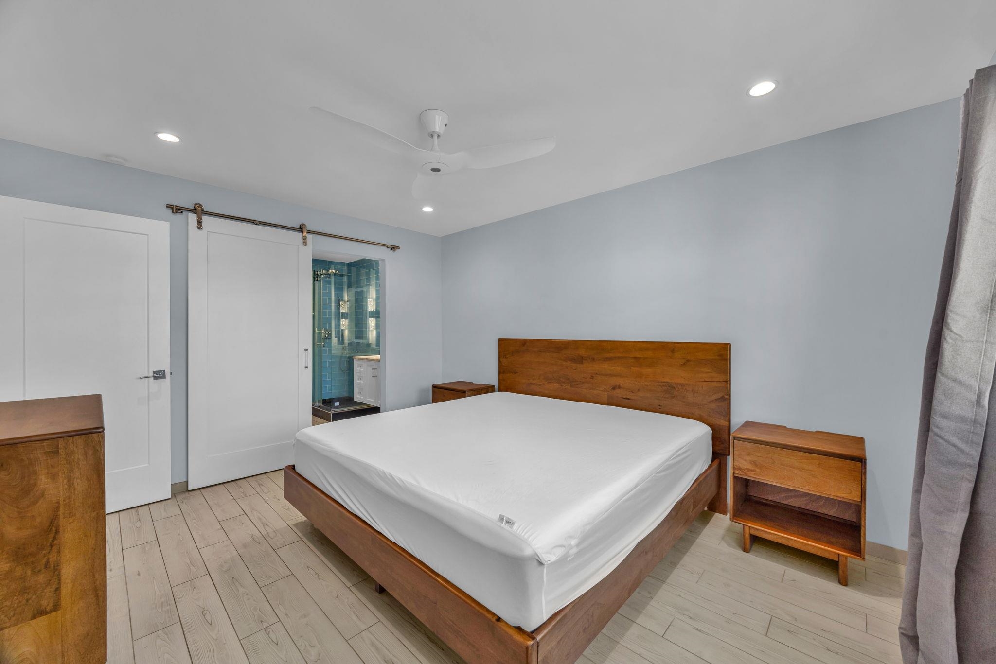 100 Auhana Road, Unit 103 Kihei, HI 96753 - Photo 27 of 43 a bedroom with a bed and a night stand