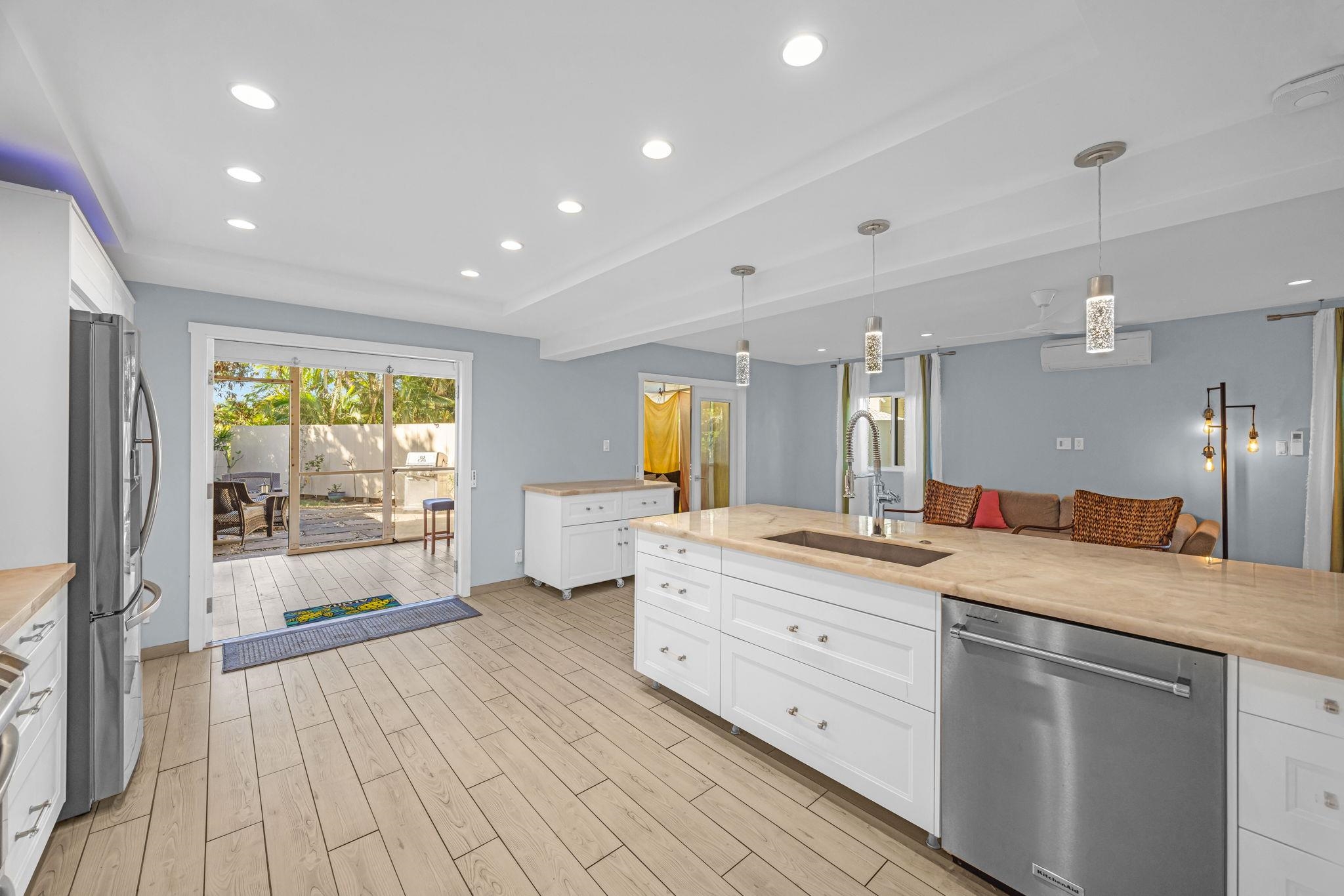 100 Auhana Road, Unit 103 Kihei, HI 96753 - Photo 8 of 43 a large kitchen with stainless steel appliances a large counter top a sink and a refrigerator