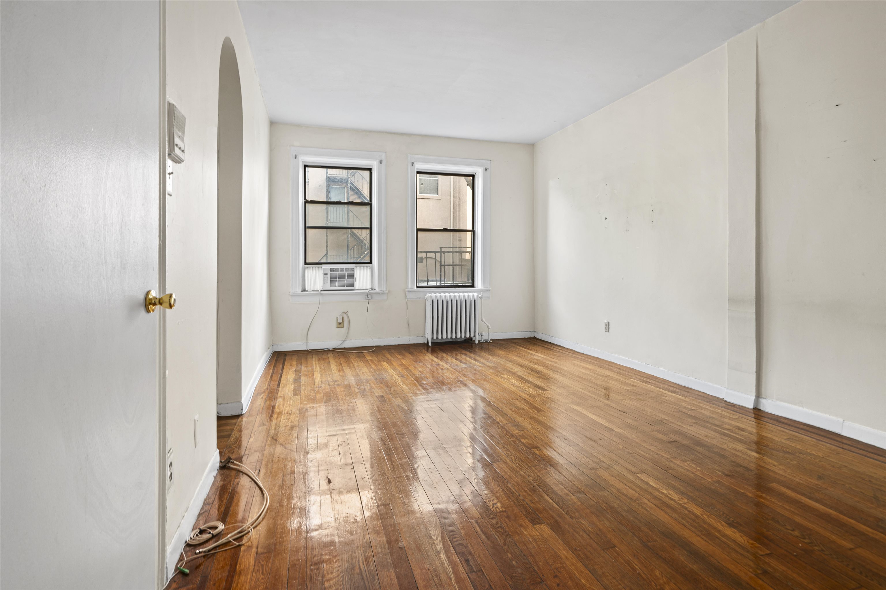 821 Bergen Avenue, Unit B5 Jersey City, NJ 07306 - Photo 3 of 13 an empty room with wooden floor and windows