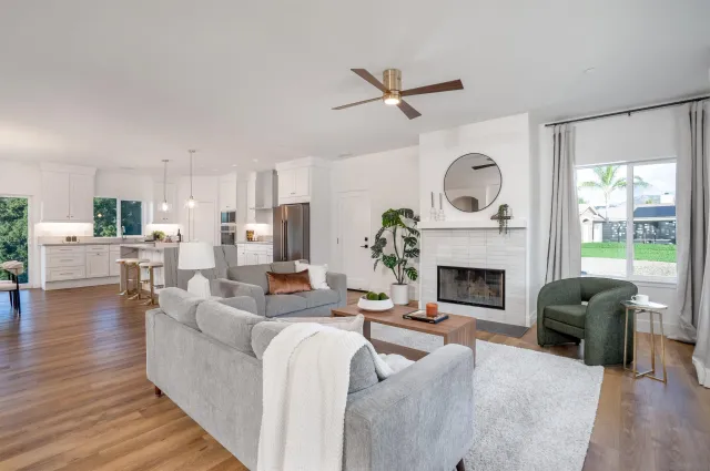 a living room with furniture a fireplace and a large window