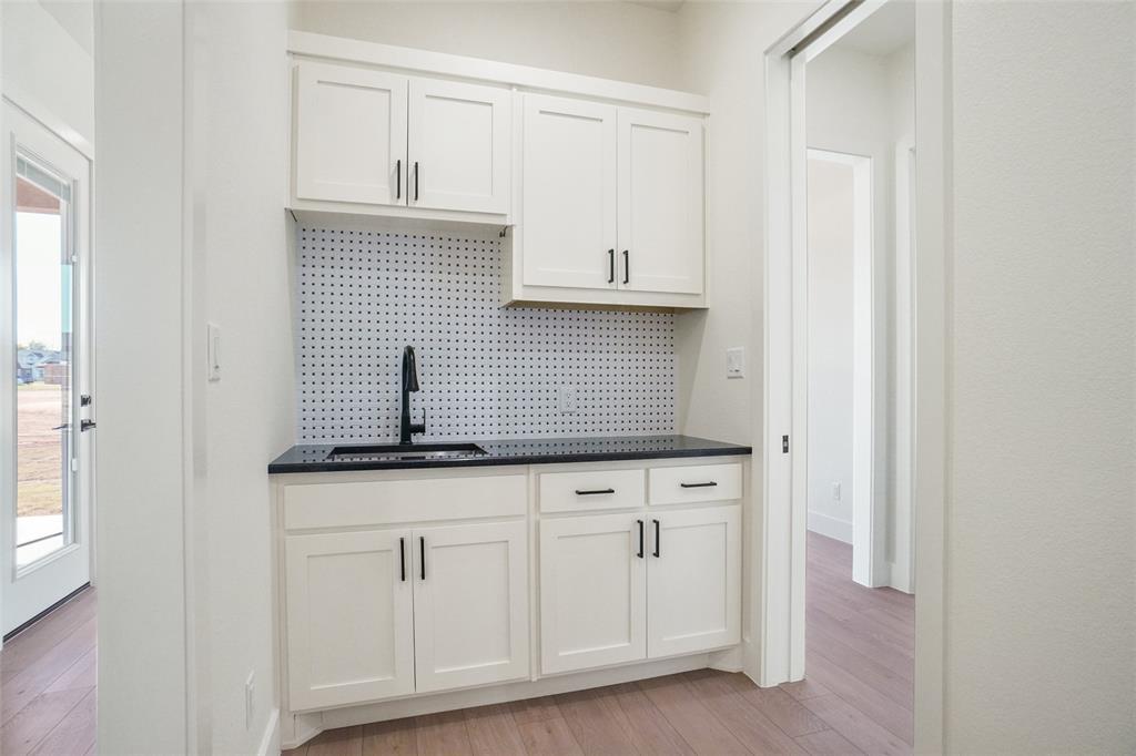 207 Stuart Street Paradise, TX 76073 - Photo 13 of 30 a kitchen with granite countertop white cabinets and sink