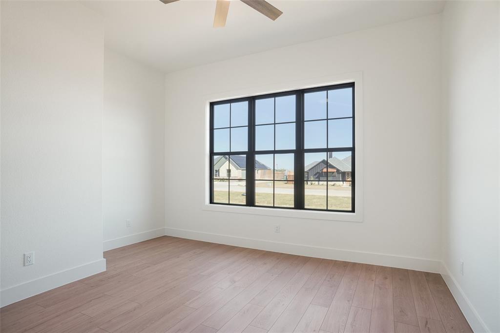 207 Stuart Street Paradise, TX 76073 - Photo 20 of 30 an empty room with wooden floor and windows