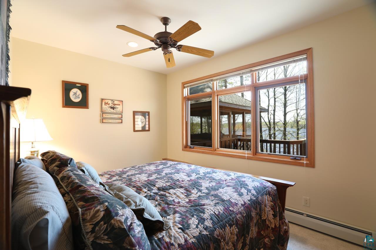 1880 Everett Bay Road Tower, MN 55790 - Photo 13 of 50 Carpeted bedroom with a baseboard heating unit and ceiling fan
