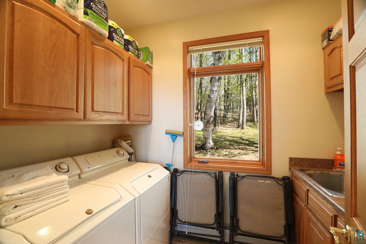 1880 Everett Bay Road Tower, MN 55790 - Photo 18 of 50 Laundry room featuring washer and clothes dryer and cabinet space