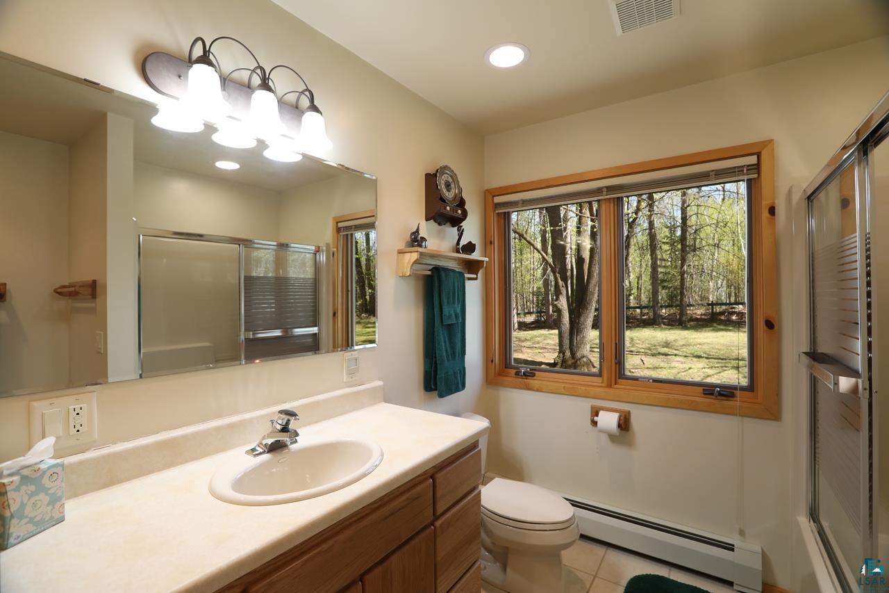 1880 Everett Bay Road Tower, MN 55790 - Photo 34 of 50 Bathroom featuring a baseboard radiator, a shower stall, tile patterned floors, vanity, and recessed lighting