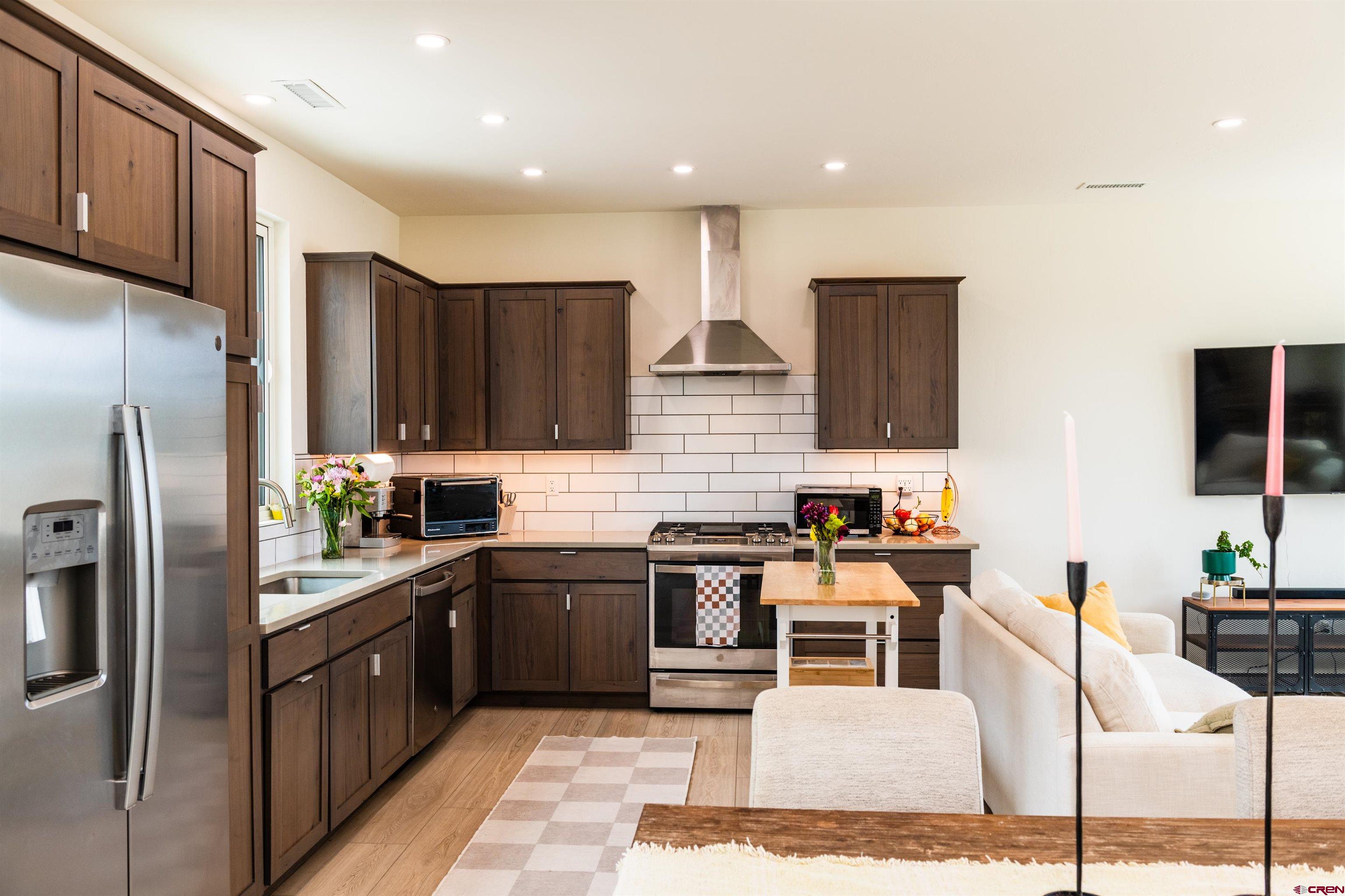 101 Elevation Drive Durango, CO 81303 - Photo 6 of 25 a kitchen with stainless steel appliances kitchen island granite countertop a refrigerator and a stove top oven