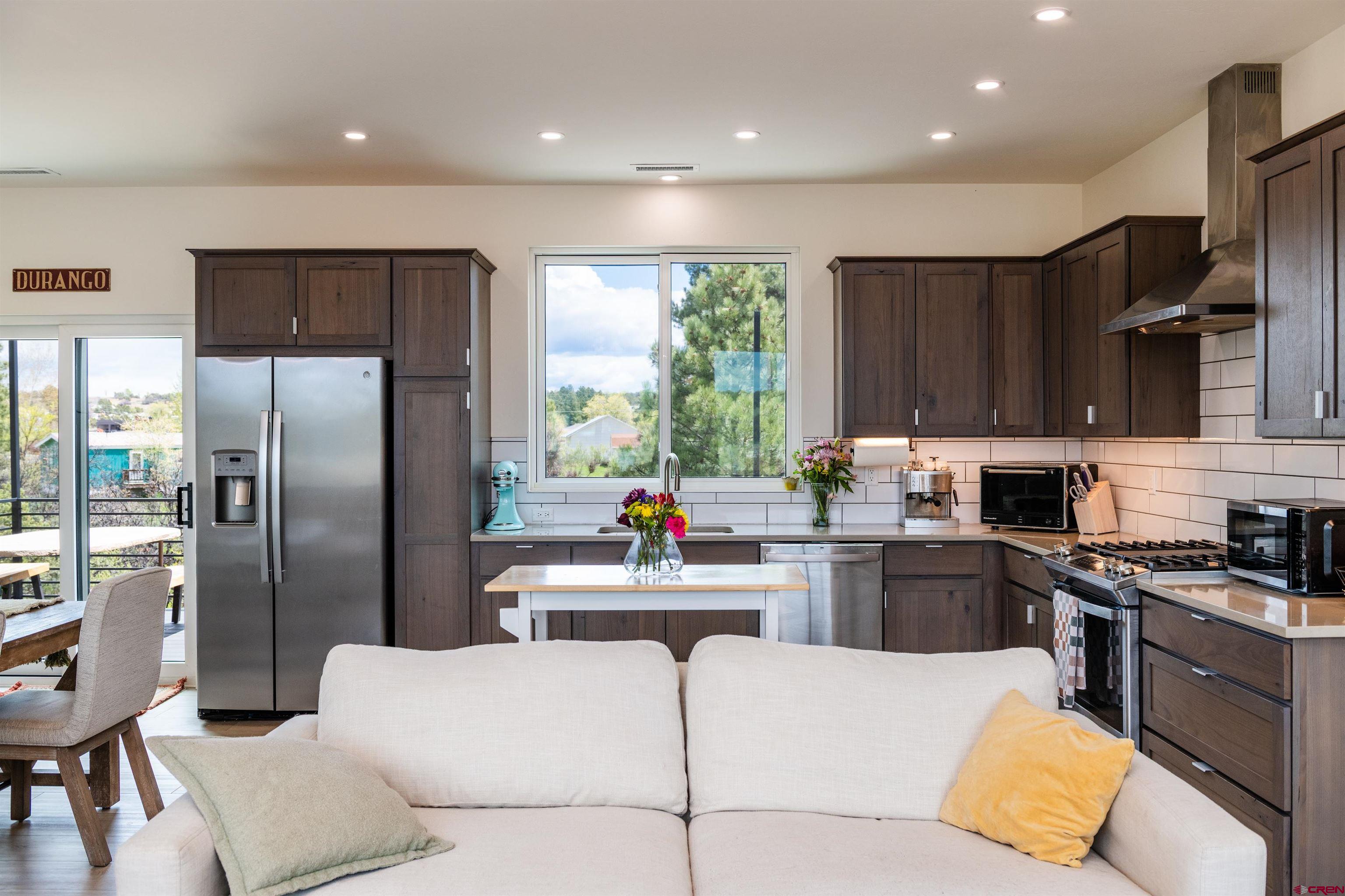 101 Elevation Drive Durango, CO 81303 - Photo 7 of 25 a kitchen with stainless steel appliances kitchen island granite countertop a refrigerator and a stove top oven