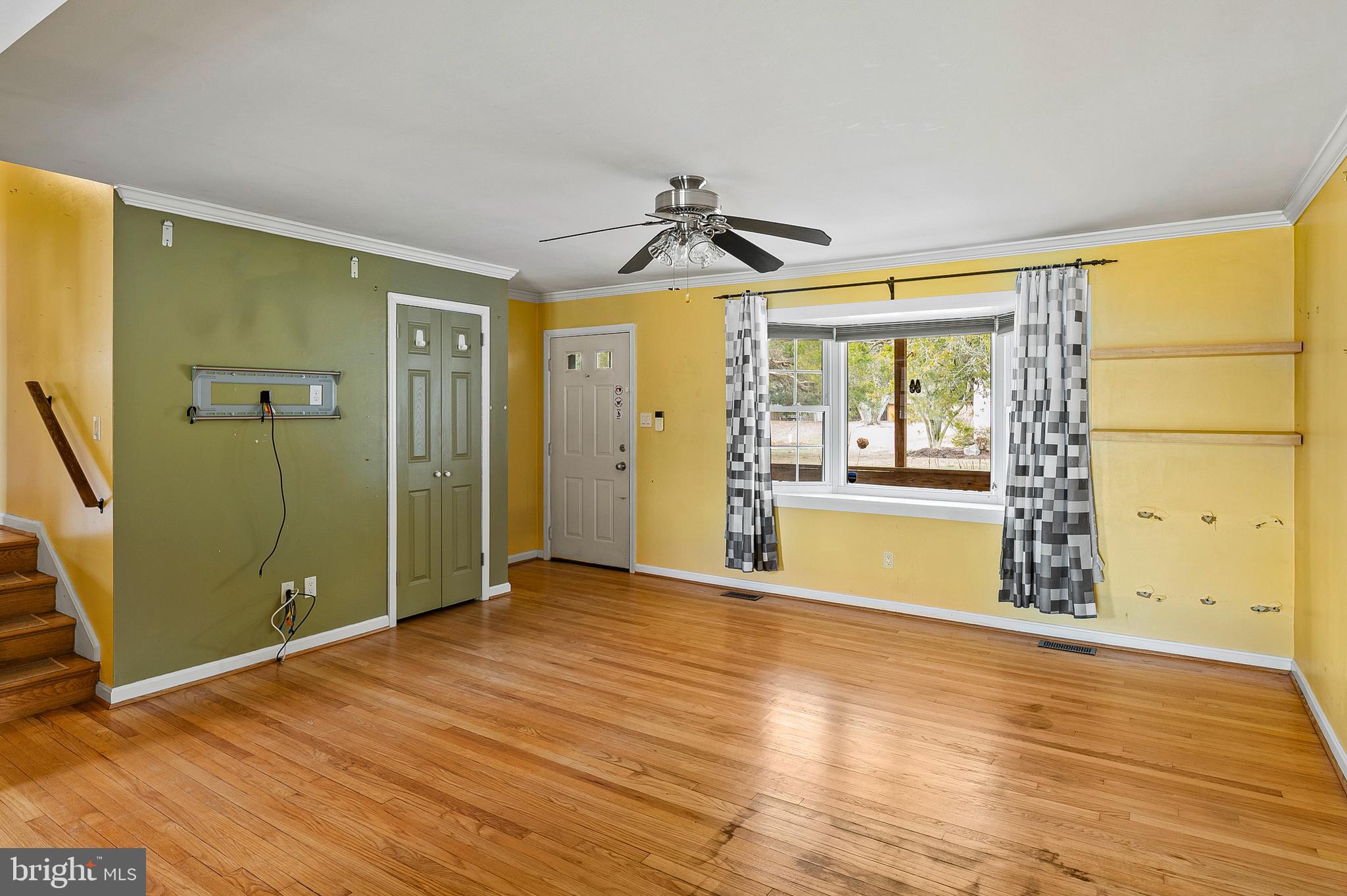 107 Holly Road Edgewater, MD 21037 - Photo 6 of 31 a view of empty room with wooden floor and fan