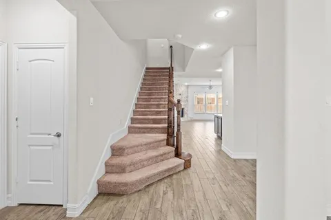 a view of entryway and hall with wooden floor