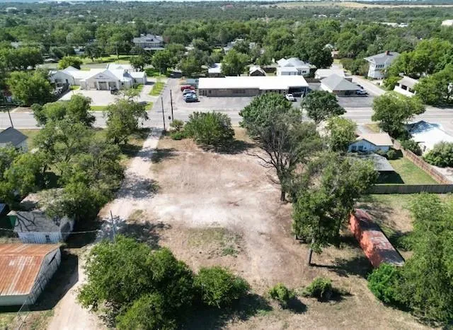 an aerial view of residential houses with outdoor space and trees all around