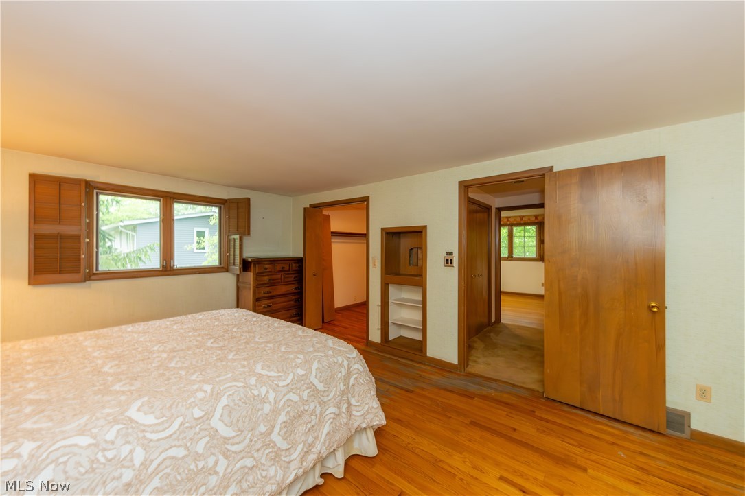 25001 Letchworth Road Beachwood, OH 44122 - Photo 26 of 50 Hardwood flooring throughout, featuring a window with integrated wooden shutters and a built-in shelving unit