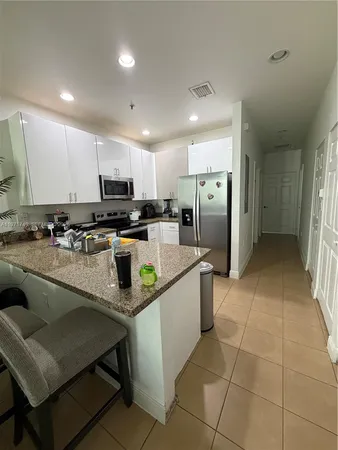 a kitchen with stainless steel appliances granite countertop a sink a stove a refrigerator a microwave a sink and cabinets