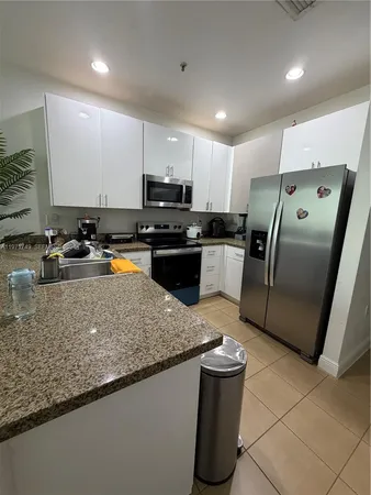 a kitchen with stainless steel appliances granite countertop a sink a stove and a refrigerator