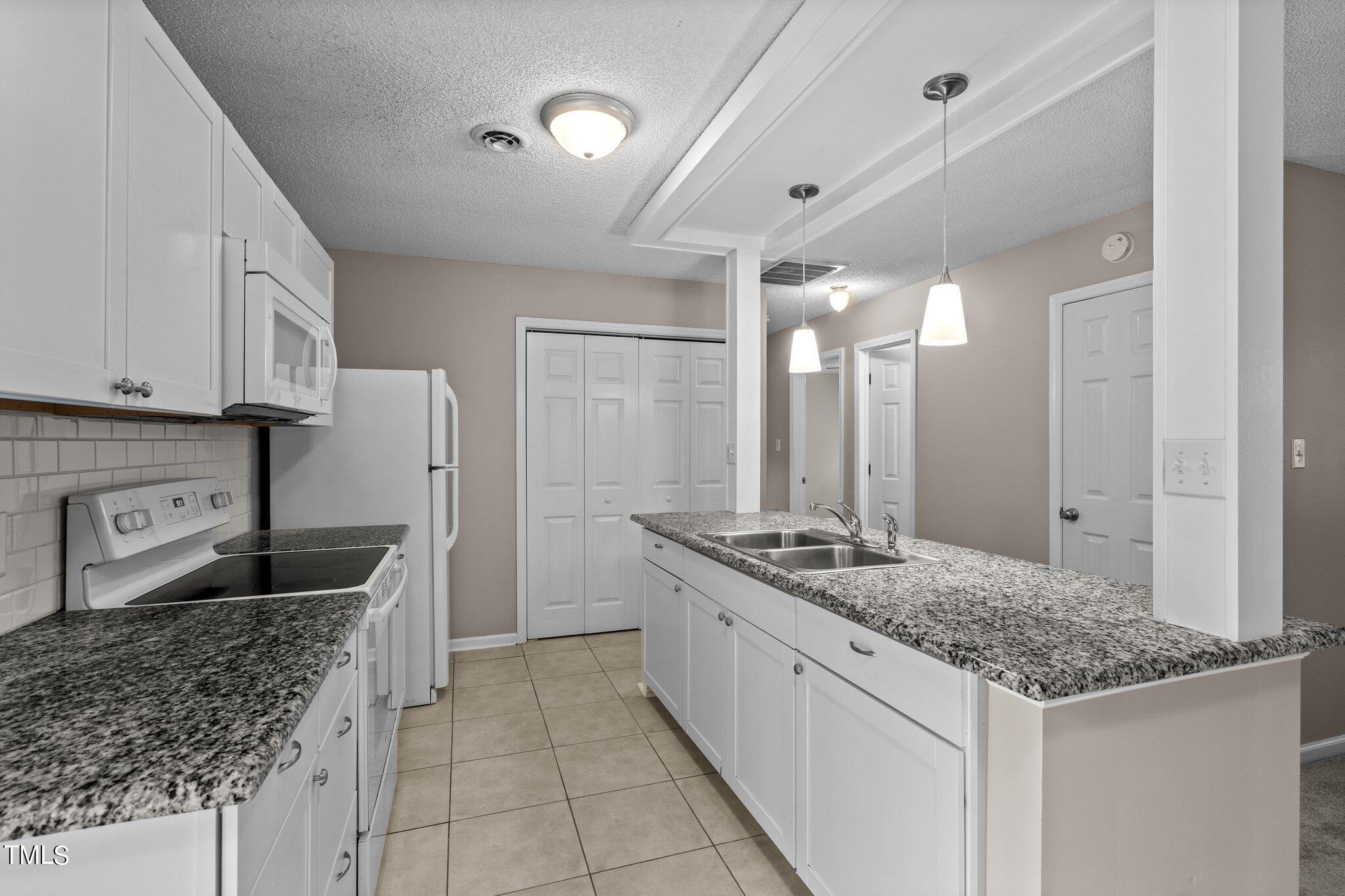 1129 Bermuda Run Knightdale, NC 27545 - Photo 11 of 34 a kitchen with stainless steel appliances granite countertop a sink stove and refrigerator