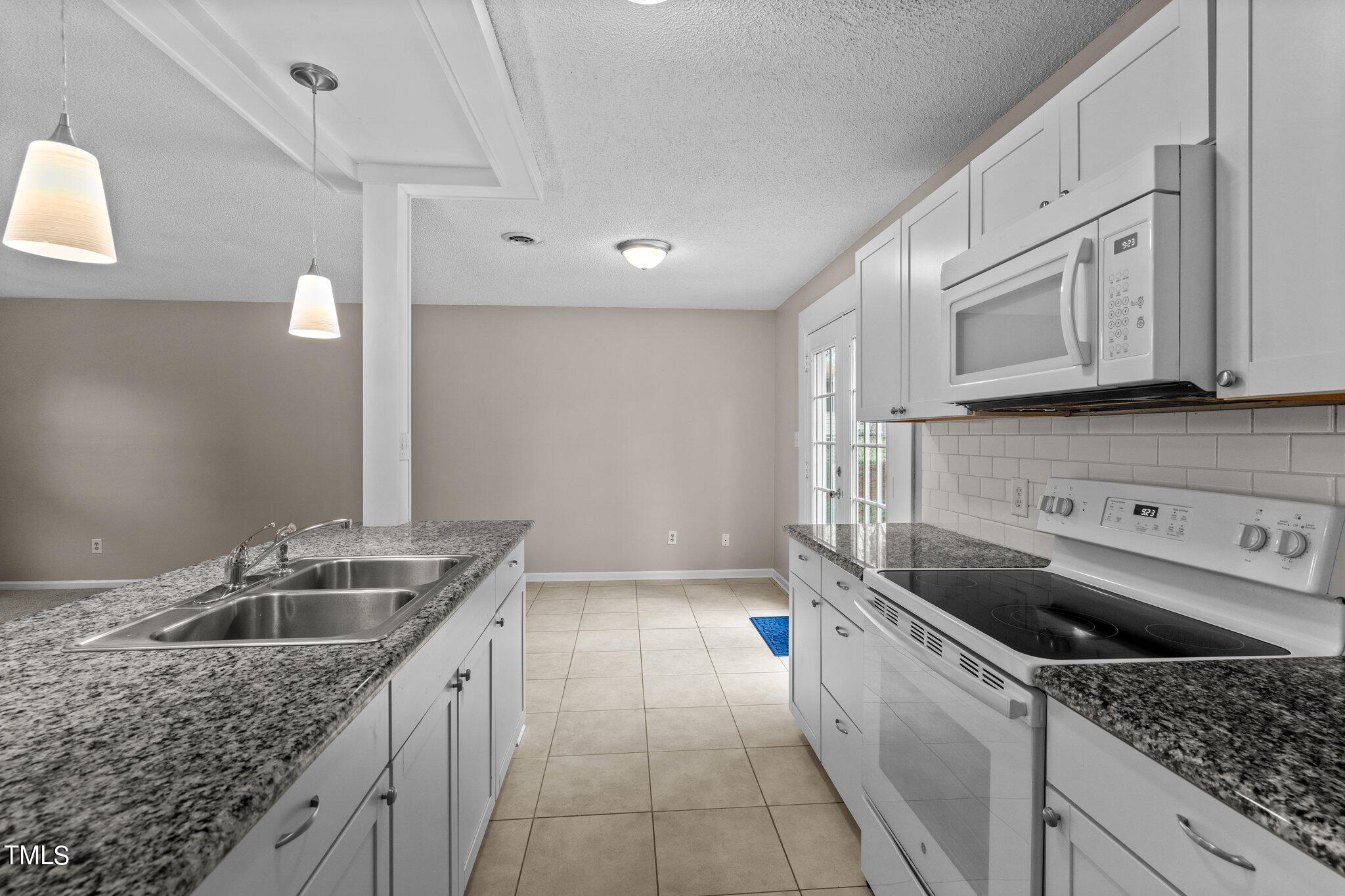 1129 Bermuda Run Knightdale, NC 27545 - Photo 12 of 34 a kitchen that has a sink and a stove