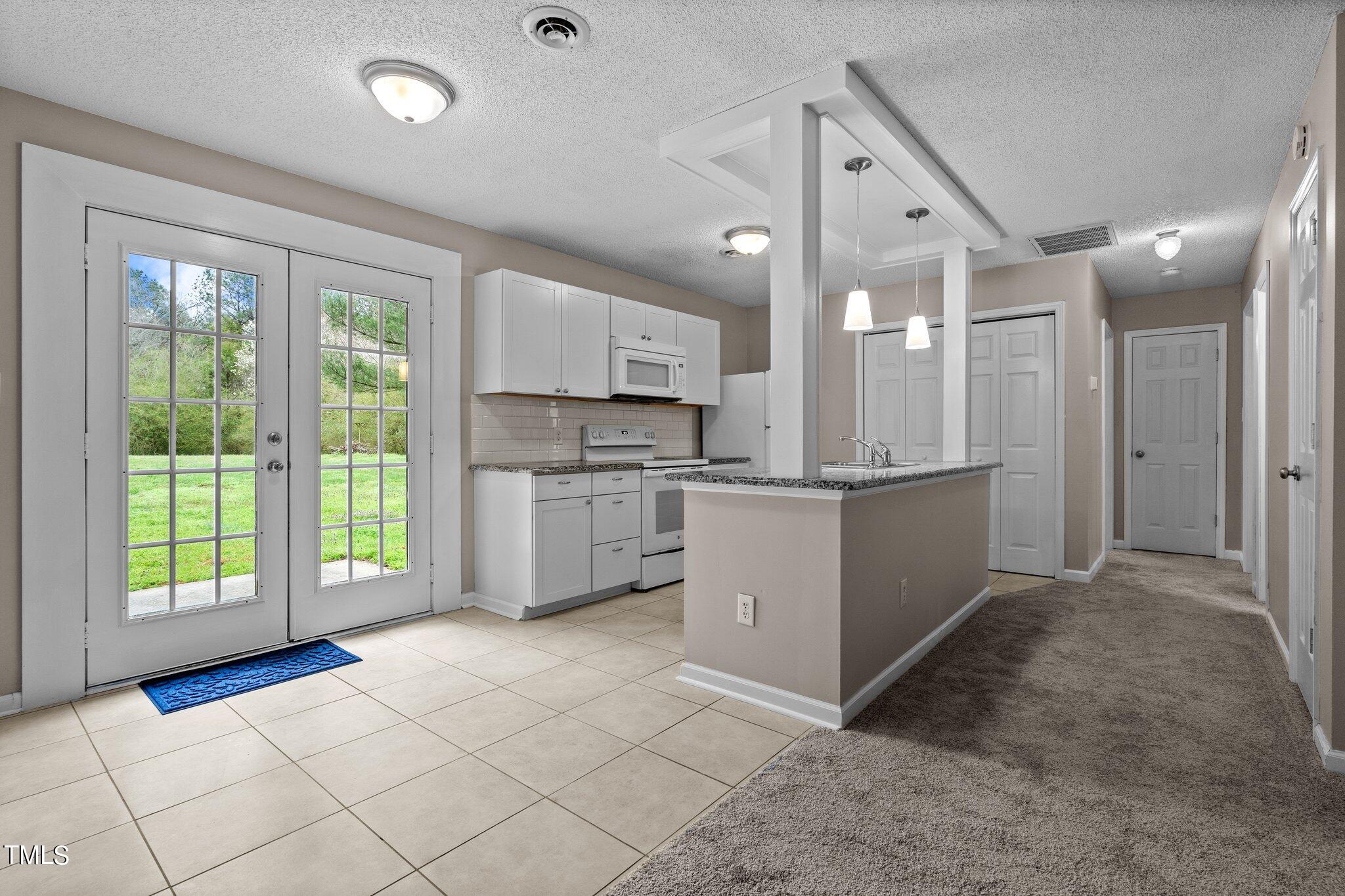 1129 Bermuda Run Knightdale, NC 27545 - Photo 8 of 34 a kitchen with stainless steel appliances kitchen island granite countertop a refrigerator and a sink