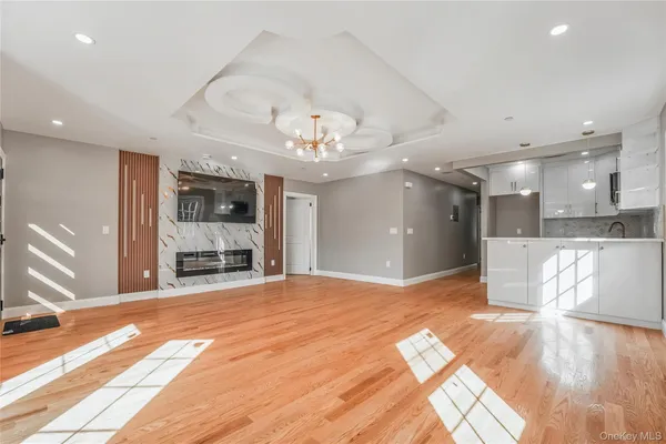 a view of an empty room with kitchen and a window