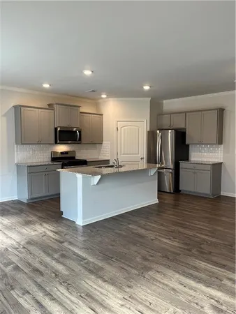 a large kitchen with a refrigerator and a stove top oven
