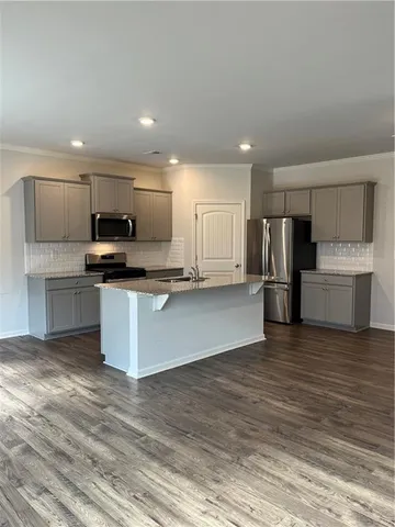 a large kitchen with a refrigerator and a stove top oven