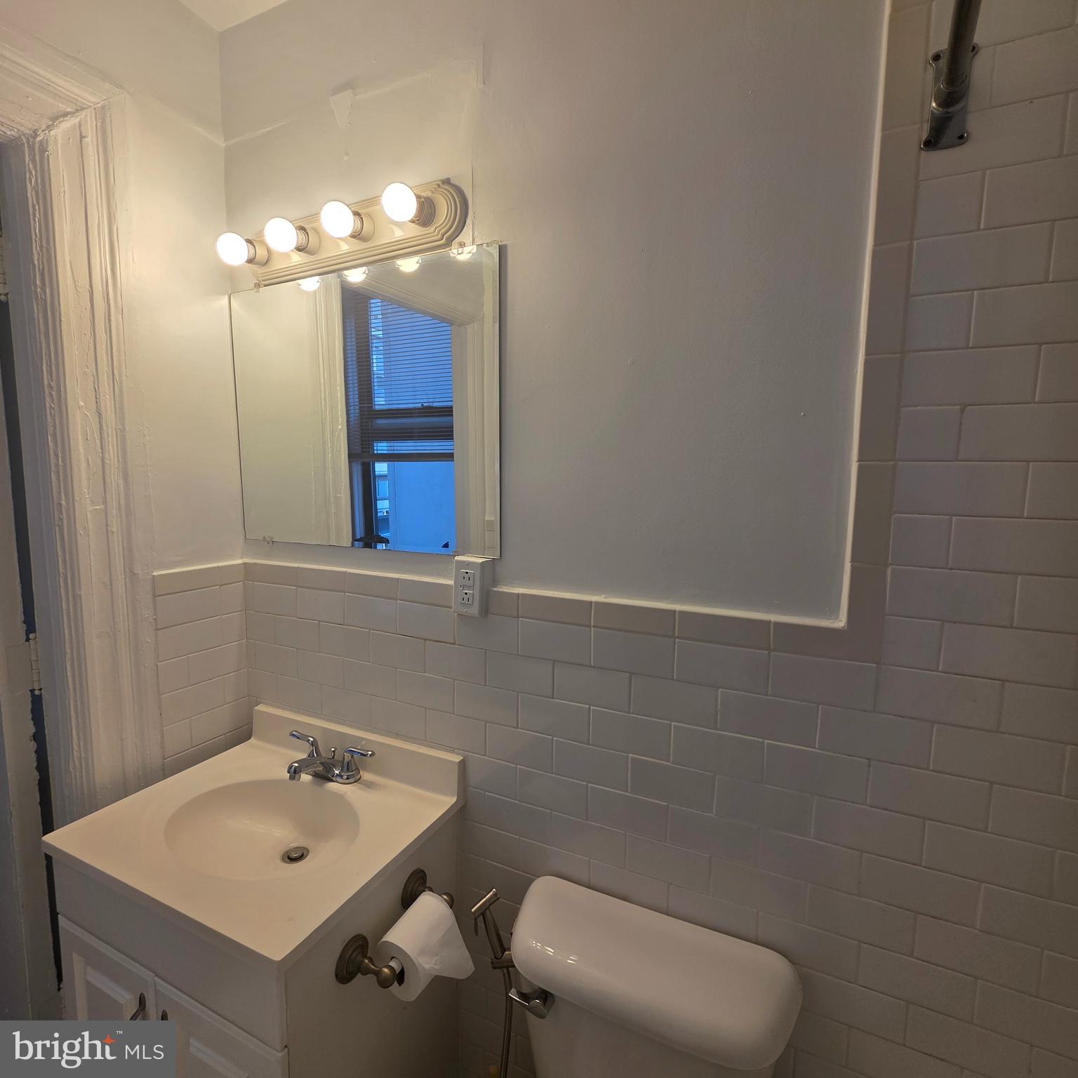 1324 Locust Street, Unit 412 Philadelphia, PA 19107 - Photo 17 of 20 a bathroom with a sink mirror and toilet