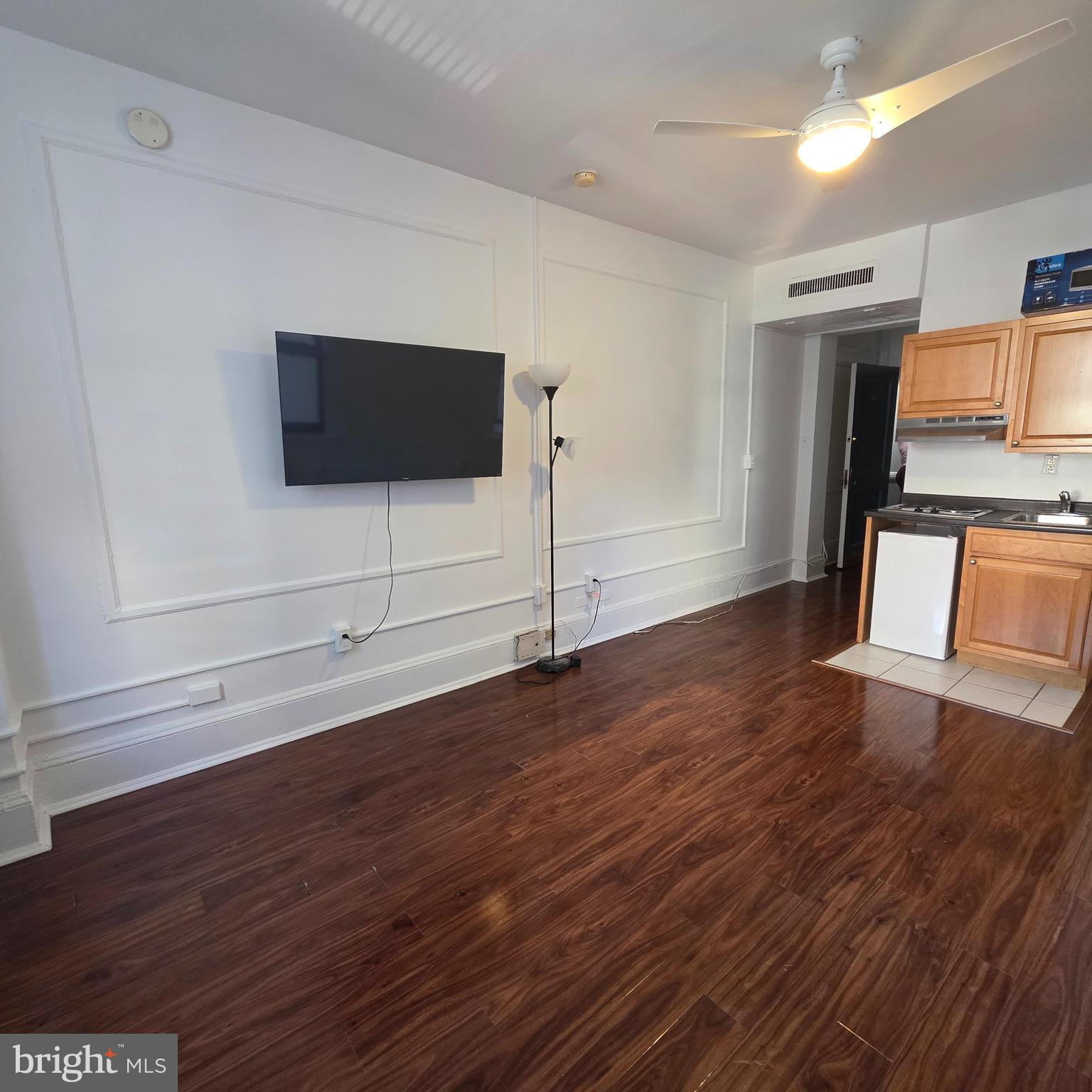 1324 Locust Street, Unit 412 Philadelphia, PA 19107 - Photo 4 of 20 a view of a livingroom with wooden floor and a flat screen tv