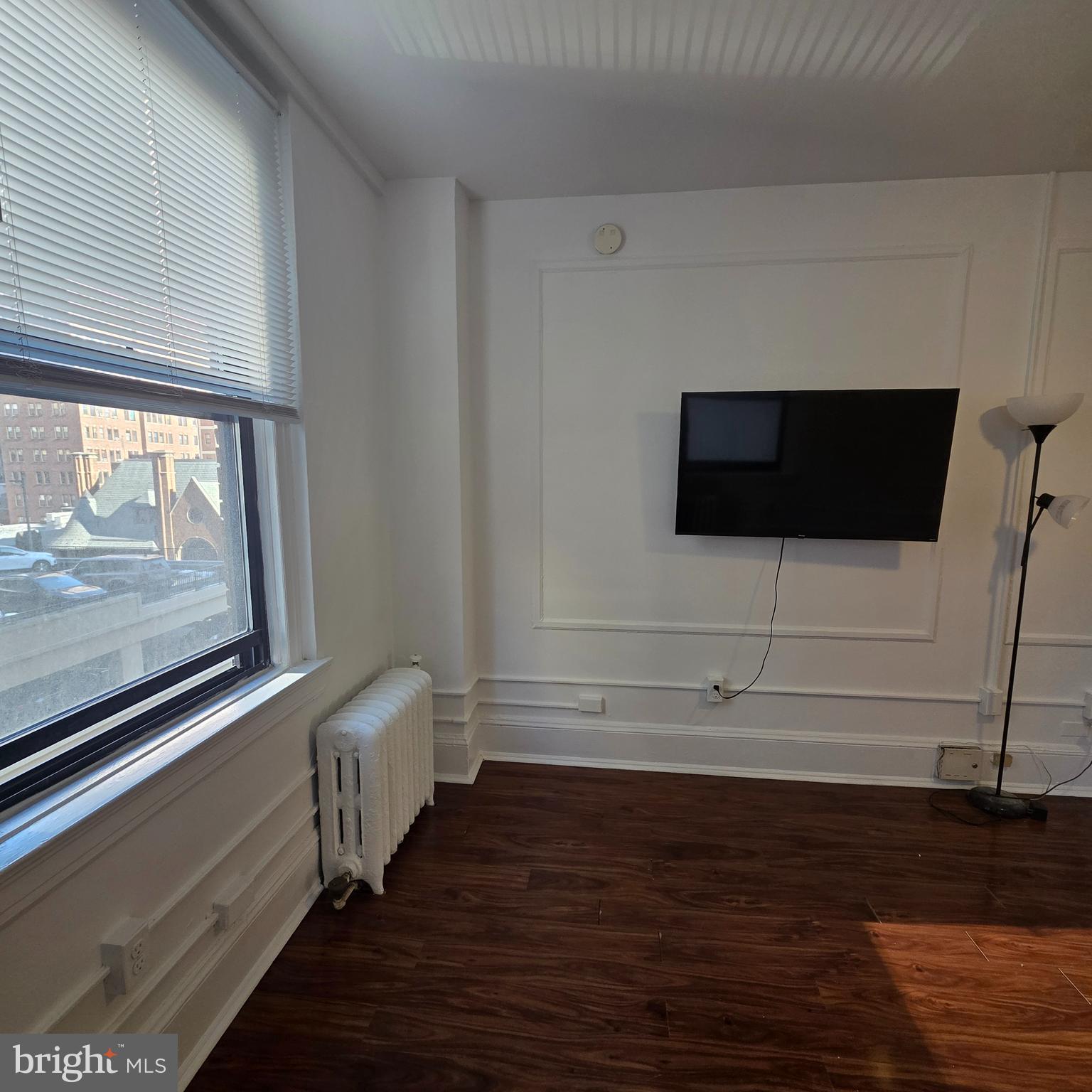 1324 Locust Street, Unit 412 Philadelphia, PA 19107 - Photo 9 of 20 a view of a livingroom with wooden floor and white walls
