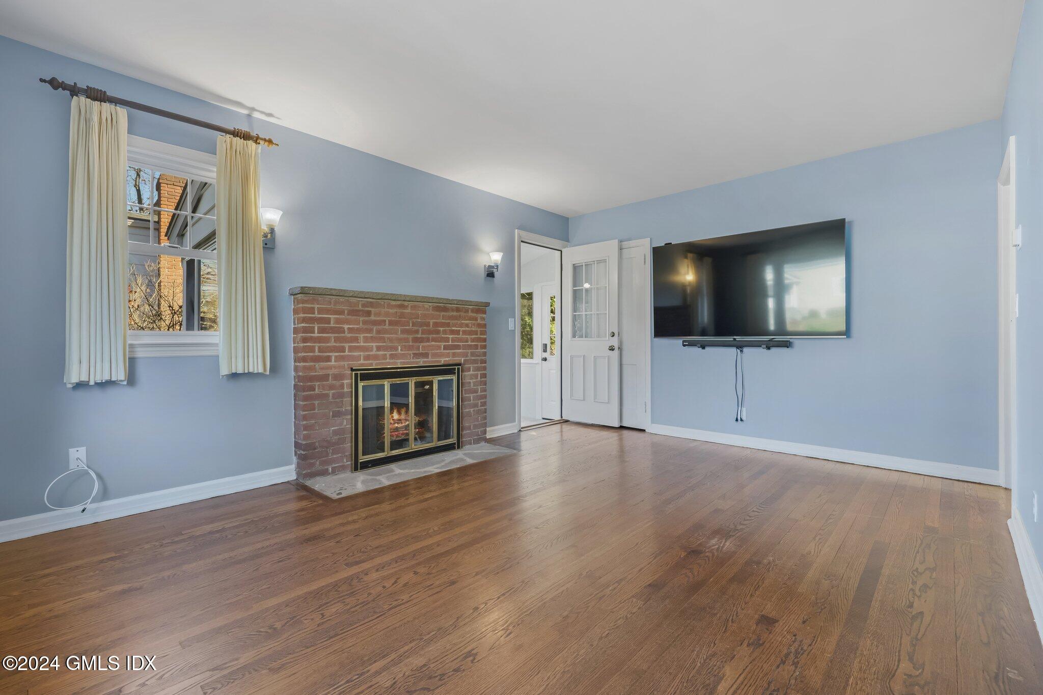 7 Hoover Road Riverside, CT 06878 - Photo 4 of 28 a living room with furniture a flat screen tv and a fireplace