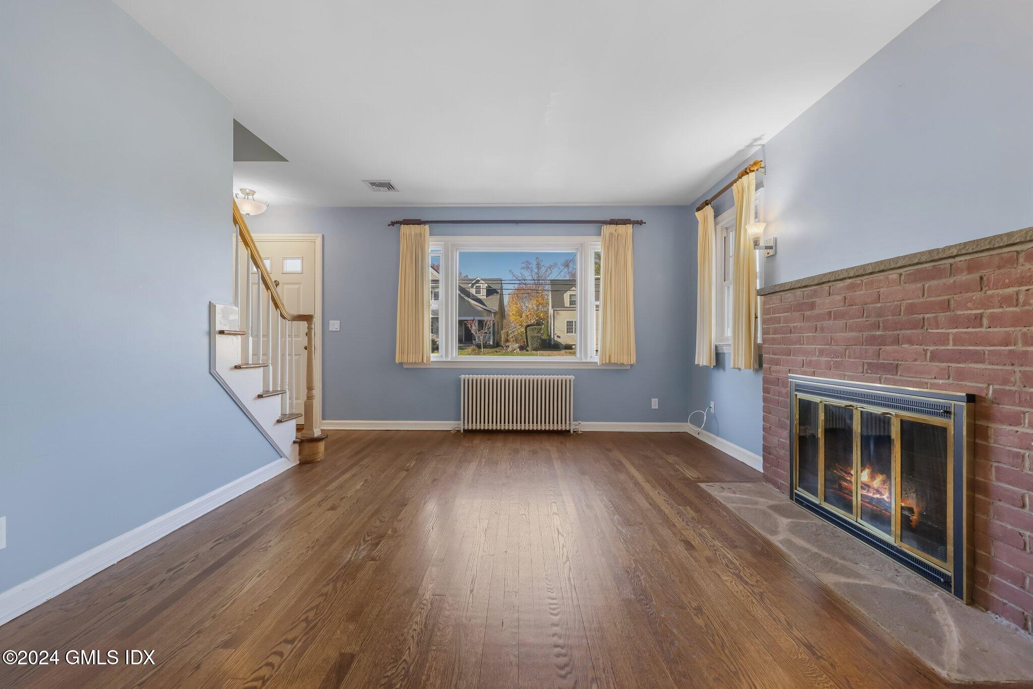 7 Hoover Road Riverside, CT 06878 - Photo 5 of 28 an empty room with wooden floor fireplace and windows