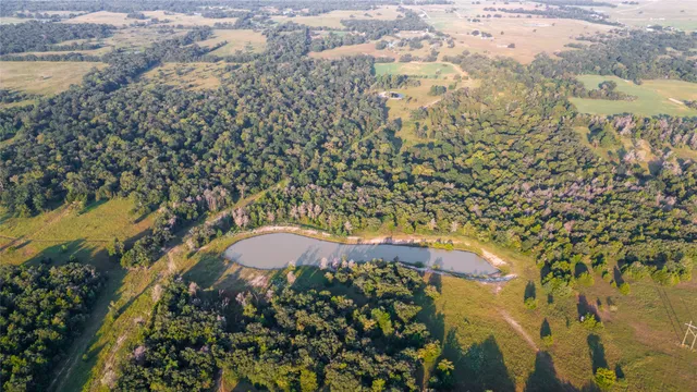 an aerial view of residential houses with outdoor space and lake view