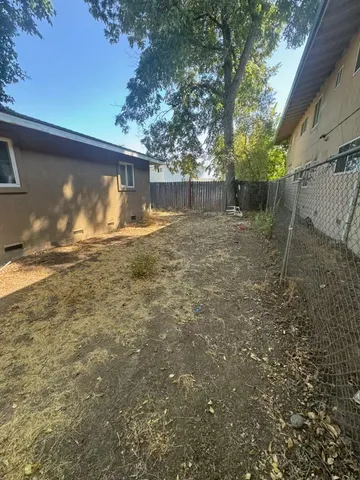 a view of a house with backyard and a tree