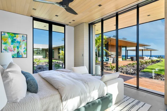 a bedroom with a large bed and a large window with outer view