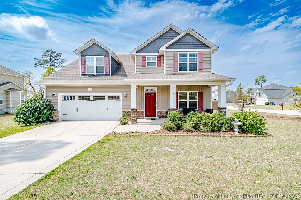 a front view of a house with a yard and potted plants