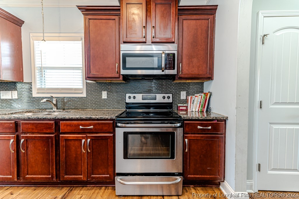 100 Lothian Ln. Cameron, NC 28326 - Photo 11 of 45 a kitchen with granite countertop a stove top oven cabinetry and granite counter tops