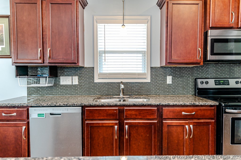 100 Lothian Ln. Cameron, NC 28326 - Photo 12 of 45 a kitchen with granite countertop stainless steel appliances a sink window and cabinets