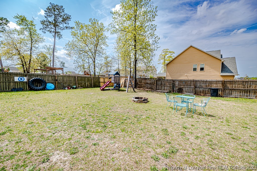 100 Lothian Ln. Cameron, NC 28326 - Photo 37 of 45 a view of swimming pool with outdoor seating and house in the background