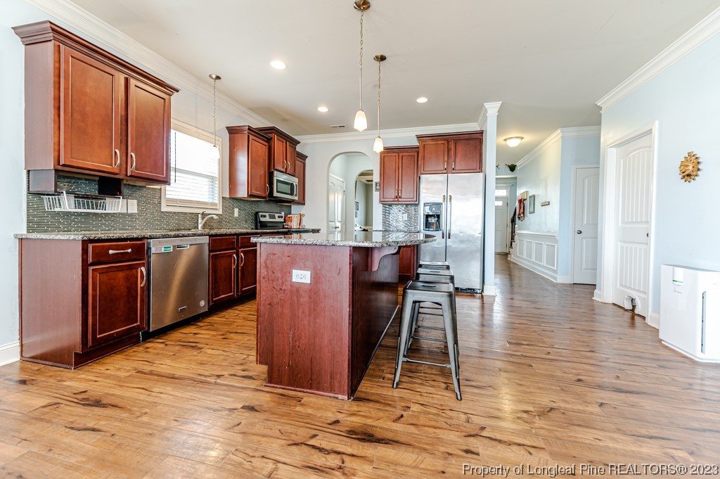 100 Lothian Ln. Cameron, NC 28326 - Photo 9 of 45 a kitchen with stainless steel appliances granite countertop a refrigerator a stove top oven a sink dishwasher and white cabinets