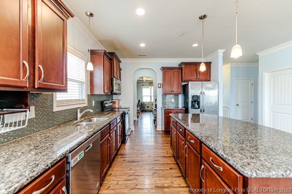 100 Lothian Ln. Cameron, NC 28326 - Photo 10 of 45 a large kitchen with kitchen island granite countertop a large counter top and stainless steel appliances