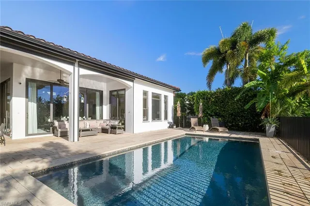 a view of a house with pool and sitting area