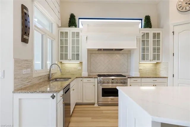 a kitchen with stainless steel appliances granite countertop a stove and a sink