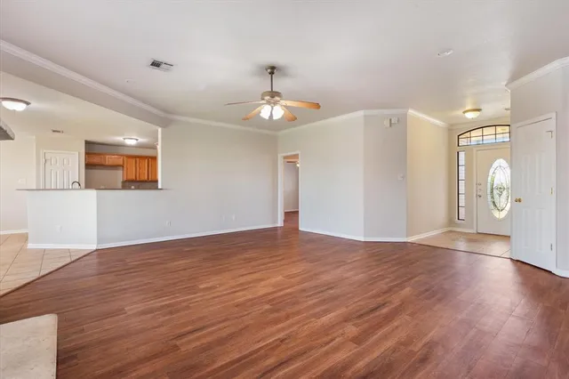 a view of an empty room with window and wooden floor
