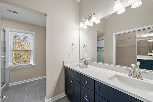 a bathroom with a double vanity sink and a mirror